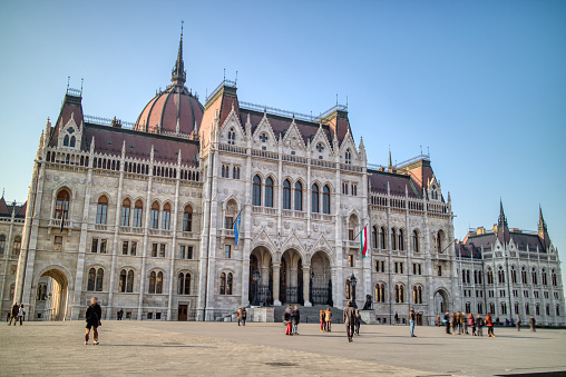 Beautiful building of the Hungarian paliament built in the gothic revival architectural style on a background of clear blue sky in Budapest, Hungary.