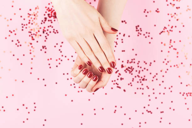 istock Two woman hands and falling confetti on pink background. 1252682852