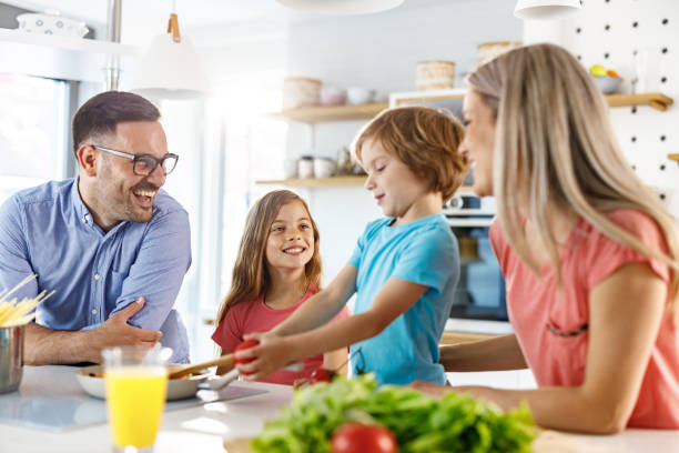 istock Young happy family talking while preparing a meal in the kitchen. 1252683391