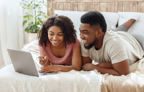 istock Laughing black couple watching funny content on laptop 1252688236