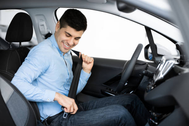 istock Smiling Guy Putting On Seat Belt Sitting In Car 1252689724
