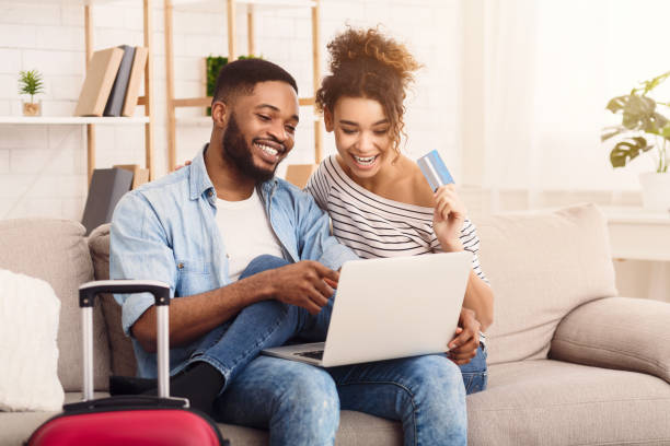 istock Spouses Using Laptop Booking Tickets Sitting On Sofa At Home 1252690727