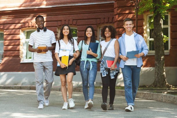 istock Happy multicultural students walking near university campus together 1252691295