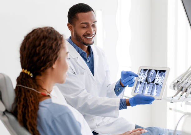 istock Dentist and patient looking at xray picture on digital tablet 1252691450