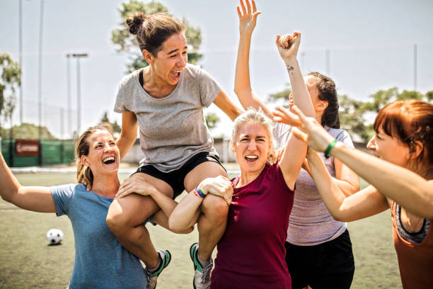 Group of women, girls soccer team on the field outdoors, training together, celebrating success