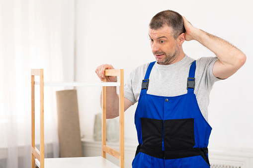 A homeowner is caulking door moldings using a silicone sealant and a caulk gun