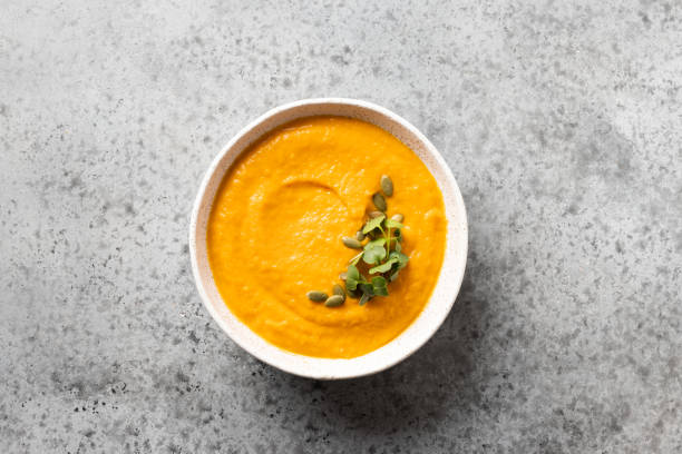 istock Pumpkin soup garnish microgreens on grey stone. Top view. 1252696884