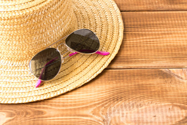 istock Sunglasses on a straw hat on a wooden table. 1252697646