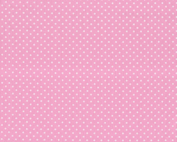 istock White polka dot over pink fabric texture background. 1252699020