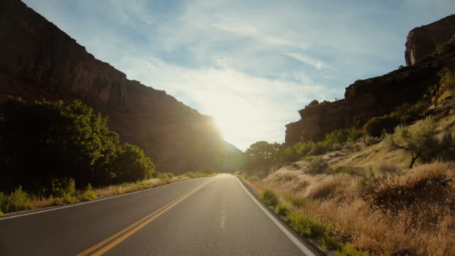 POV car driving in USA Southwest: straight road and majestic sunset outdoors