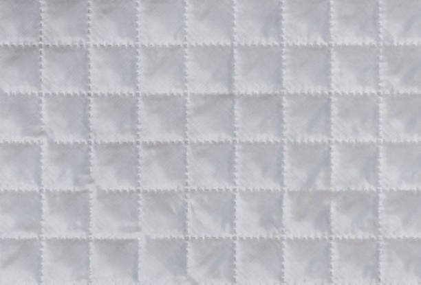 istock White cloth or material texture with checkered structure or embossing. Synthetic fabric pattern or background. Macro, close up shot 1252700415
