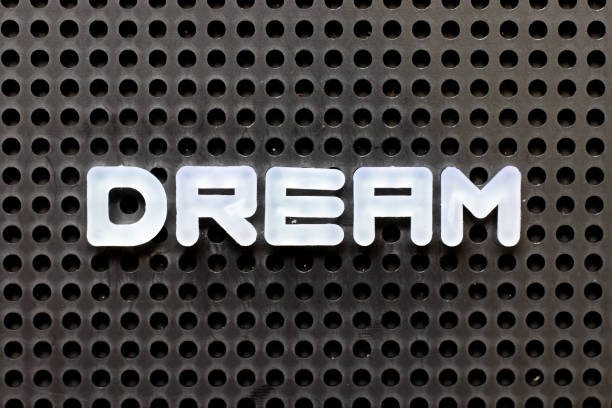 istock White color alphabet with word dream on black pegboard background 1252700507