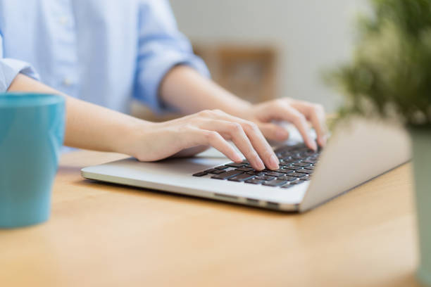 istock Close up female hand using laptop texting working from home. 1252700650