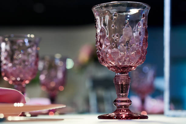 крупным планом стеклянной чашки розового стекла виноградной лозы на столе - barware стоковые фото и изображения