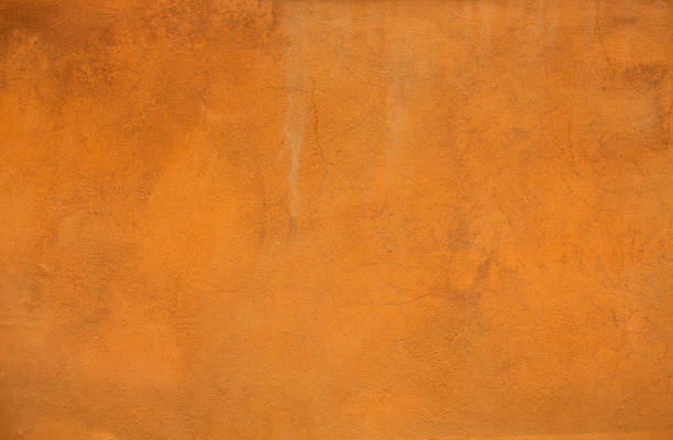 istock Orange color stucco background or texture. Bright light plastered wall of a building 1252704207
