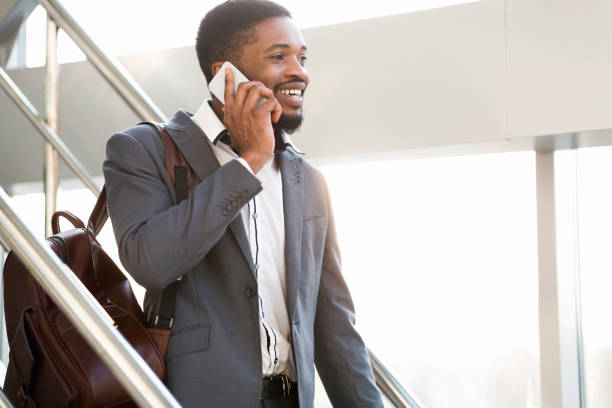 istock Man Talking On Cellphone Walking Down The Stairs In Airport 1252705628