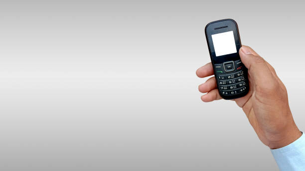 istock Asian man holding feature or keypad phone in hand 1252707468