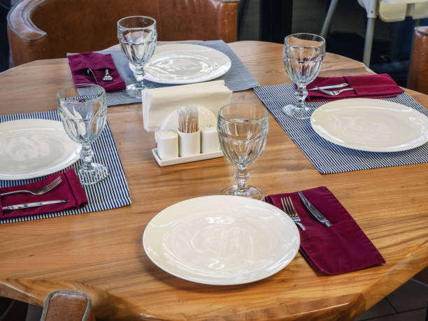 istock A table with three cutlery standing on striped napkins and one device without it. Table setting for four persons. Closeup photo 1252708790