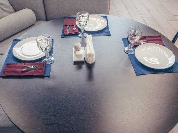 istock Round table with glasses, silverware plates and napkins. Serving for three persons. Close-up photo 1252708823