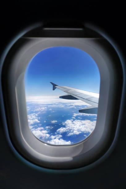 istock View through the plane window at the wing and blue cloudy sky 1252709599