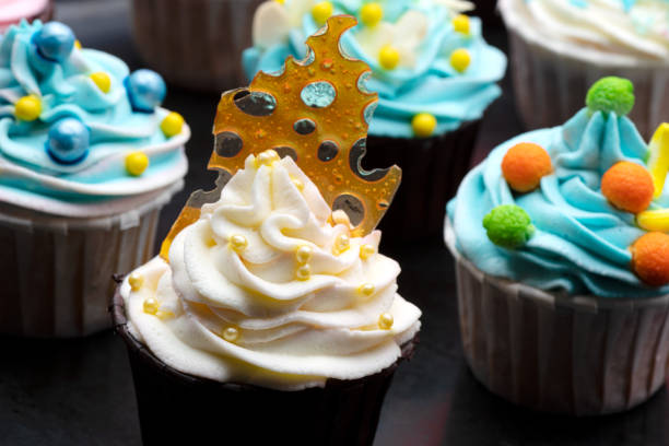 istock Colorful cupcakes with different modern decoration on black plate. Horizontal close up view 1252711825