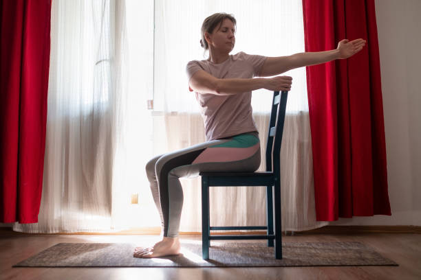 Woman working out doing yoga or pilates exercise using chair.