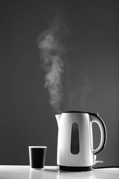 istock Electric white kettle and paper cup on grey background 1252716003