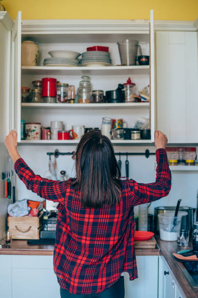 Housewife organizing the kitchen. Rear view of a young woman organizing her kitchen at home. sideboard photos stock pictures, royalty-free photos & images