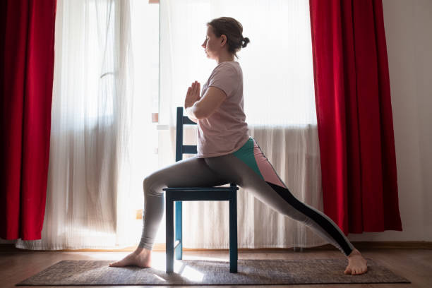 istock doing virabhadrasana warrior pose at home using chair. 1252718601
