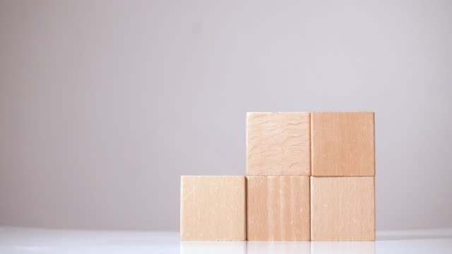 Man building some structure from wooden cubes