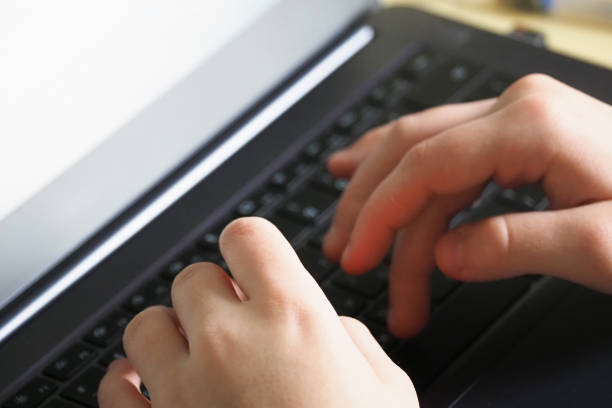 istock Work at the computer, top view. Hands on laptop keyboard, close-up. Home schooling 1252718648