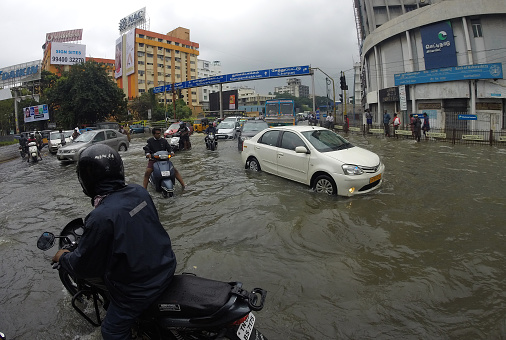 Chennai, India - 3 December 2015: Local motorists try to make their way through a flooded major intersection in Chennai. Record rain fall has coursed major disruptions in and around Chennai with much of the city under water. Flooding has also forced the closure of the International Airport till the 6th of December 2015.