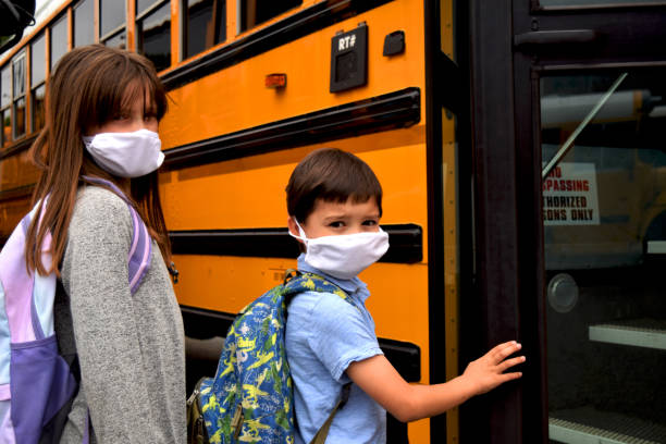 istock Two students wearing face masks board a school bus 1252718824