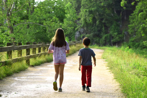 istock Two children walking down a dirt path v1 1252718859