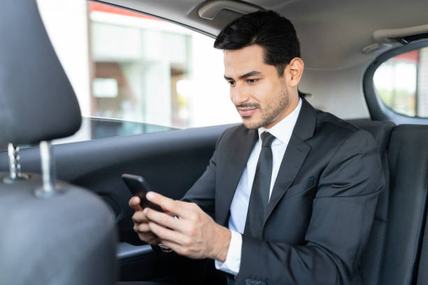 istock Young Businessman Using Smartphone In Taxi 1252719296
