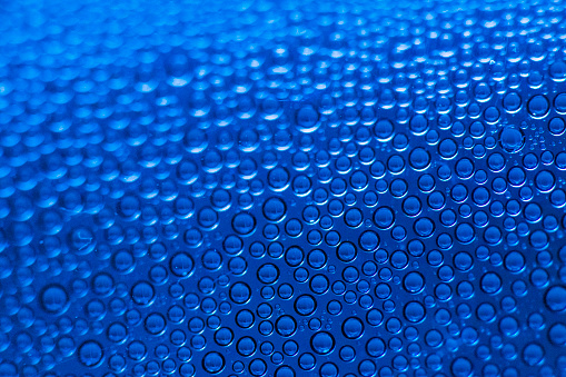 Equal size water droplets curve into infinity textured background