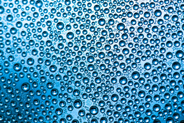 Perfect drops of water across a backlit blue background