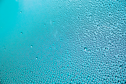 Multiple tiny water droplets on a turquoise surface