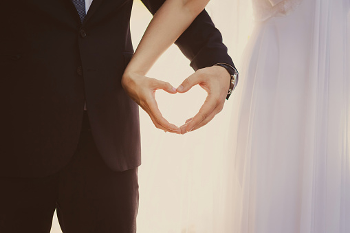 The bride and groom hands forming heart shape a symbol of love