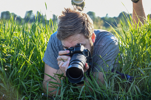 A professional photographer photographs flowers in a nearby field