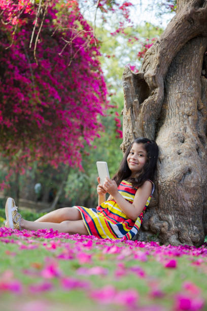 ragazza nel parco pubblico - children only tree area exploration freshness foto e immagini stock