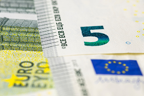 Macro shot of a European Union banknote of 5 EUR, close-up of the number five.