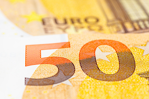Macro shot of a European Union banknote of 50 EUR, close-up of the number fifty, selective focus.