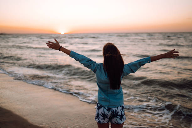 istock Girl enjoys vacation on the beach at sunset. 1252736717