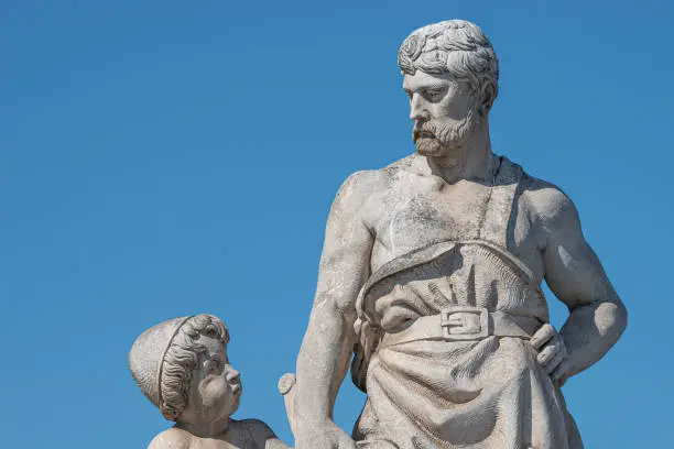 Photo of Elderly and young – old sculpture of engineer and his scholar on Zoll Bridge in Magdeburg downtown at blue sky background, Germany, details, closeup