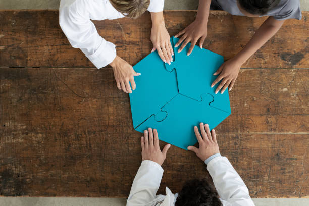 istock Professionals assembling 3 par puzzle piece, aerial view 1252738513