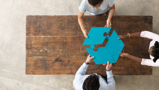 istock Professionals assembling 3 par puzzle piece, aerial view 1252738517