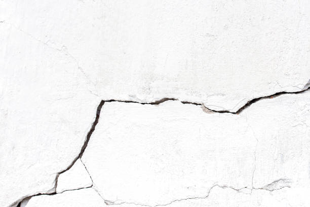 istock White concrete cracked wall with large crack, background or texture 1252738608
