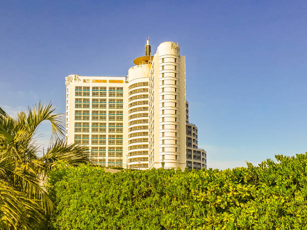 rustic white hotel building architecture facade exterior landmark view foreshortening from below on vivid blue sky background travel vacation destination apartments object
