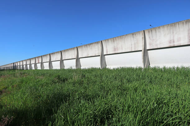 istock White cement noise barrier with green grass 1252752626